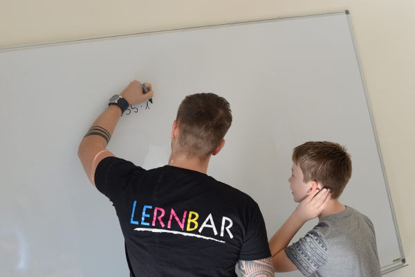 LERNBAR Lehrer erklärt Schüler am Whiteboard
